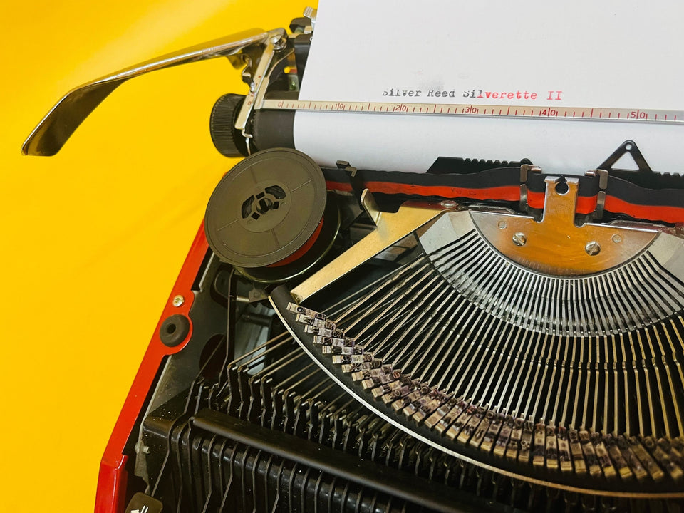 Close-up of the Silverette II branding and the sleek, low-profile red body of this 1970s Japanese typewriter.