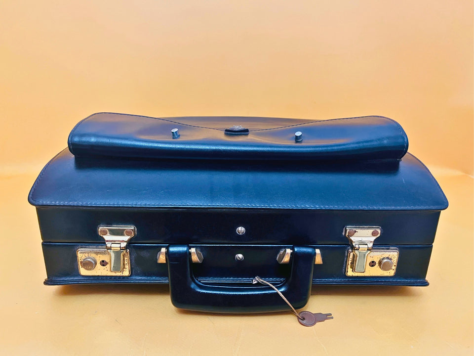 Black leather briefcase detail texture stitching and hardware close-up