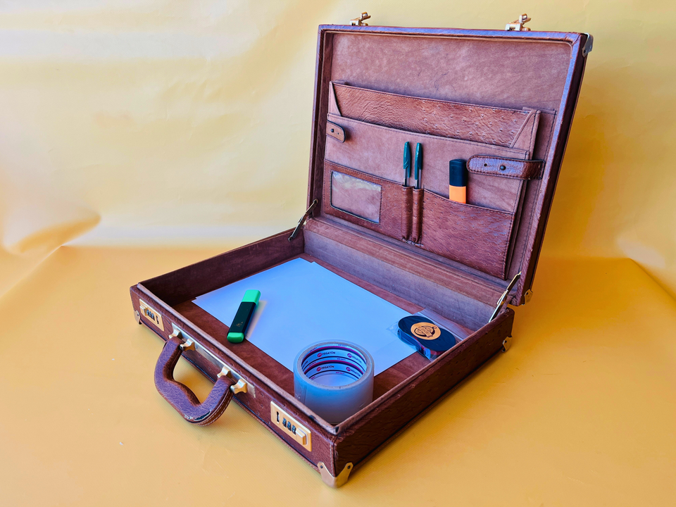 Opened view of the 1970s ostrich leather suitcase showing the clean original lining and secure internal straps