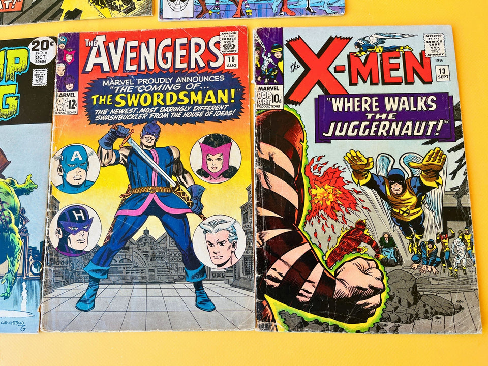 Seven vintage comic books displayed together, including Marvel and DC classics featuring Spider-Man, X-Men, Avengers, Swamp Thing, and war comics.