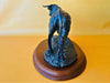 Side profile of a decorative resin bull figurine on a wooden plinth, showcasing the muscular body and realistic movement.