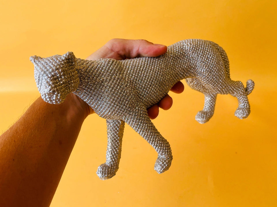 Silver jaguar figurine held in hand scale detail