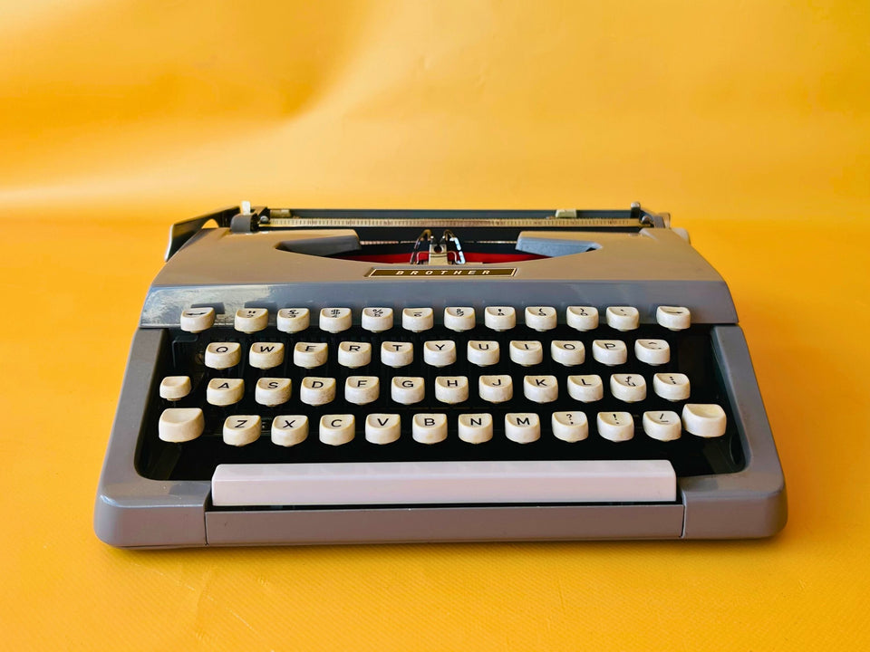 Brother Typewriter (1970s) – Gray Portable Manual Typewriter with Leather Case