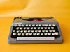 Brother Typewriter (1970s) – Gray Portable Manual Typewriter with Leather Case