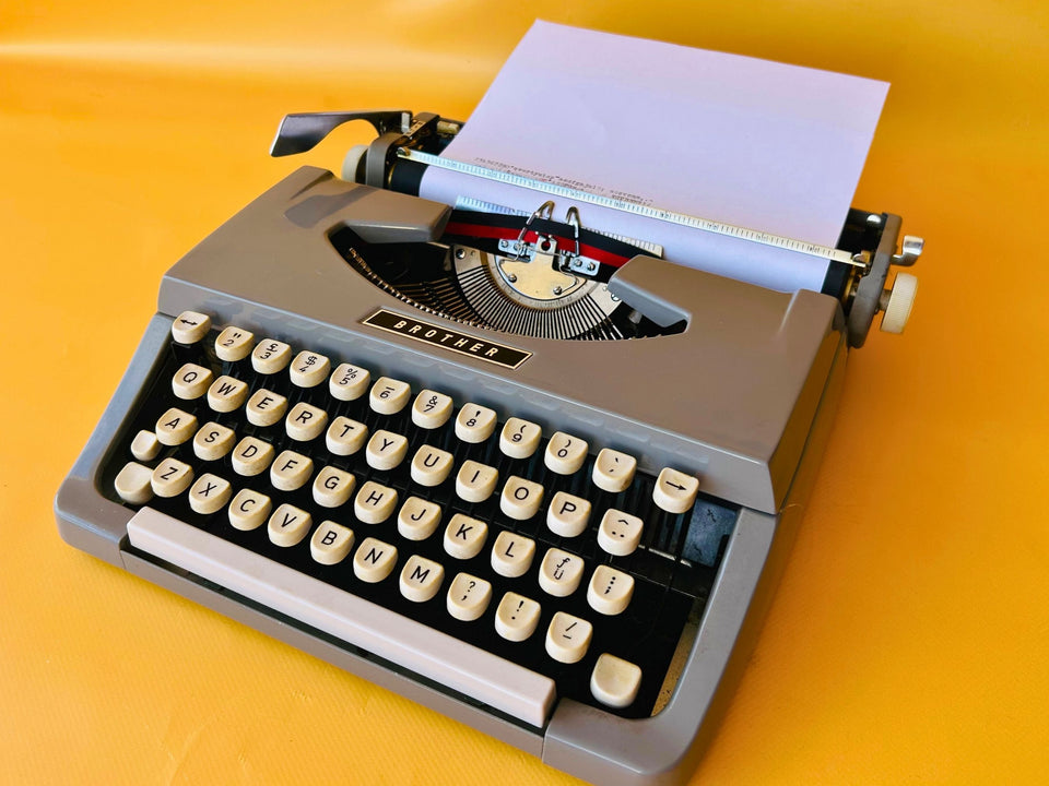 Brother Typewriter (1970s) – Gray Portable Manual Typewriter with Leather Case
