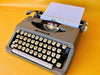 Brother Typewriter (1970s) – Gray Portable Manual Typewriter with Leather Case