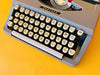 Brother Typewriter (1970s) – Gray Portable Manual Typewriter with Leather Case