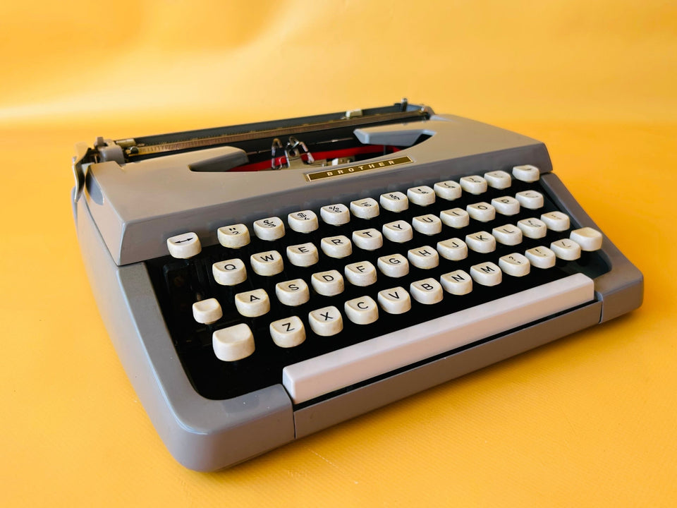 Brother Typewriter (1970s) – Gray Portable Manual Typewriter with Leather Case
