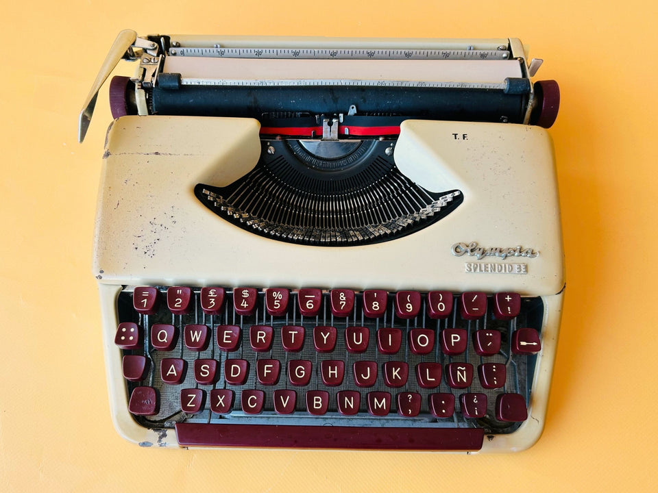 Detailed shot of the unique wine-red Spanish QWERTY keyboard on an Olympia Splendid 33 showing the Ñ key and vintage character