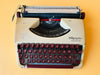 Detailed shot of the unique wine-red Spanish QWERTY keyboard on an Olympia Splendid 33 showing the Ñ key and vintage character
