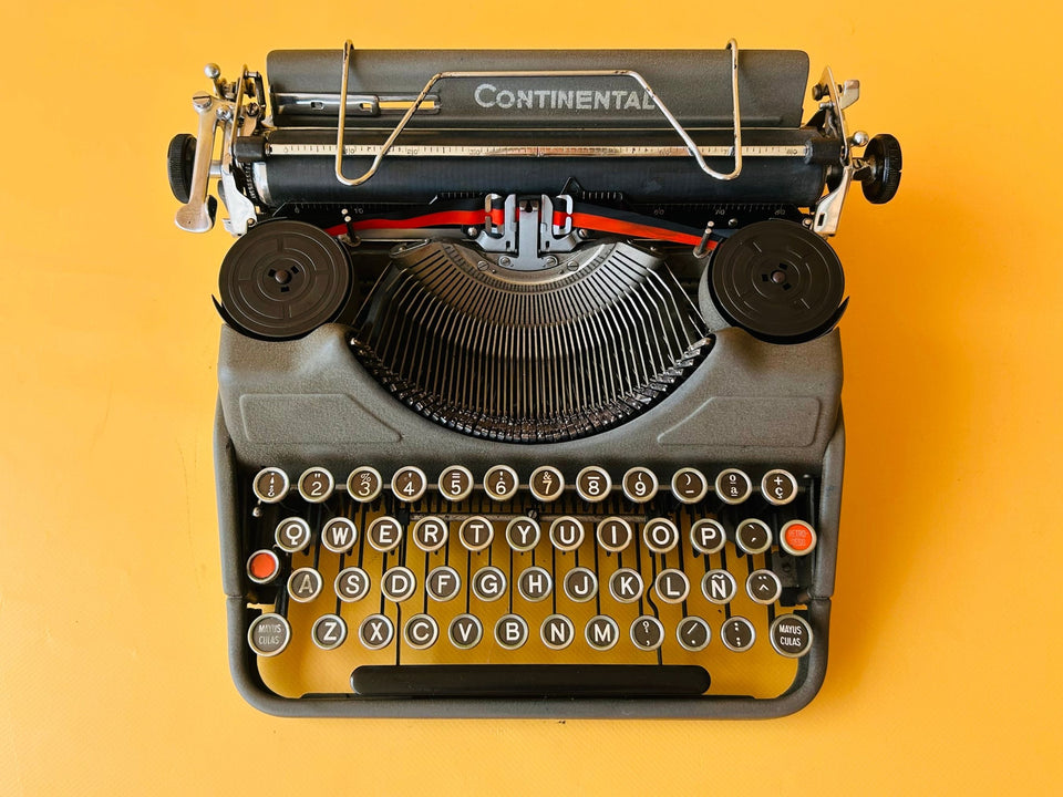 Detailed macro shot of the authentic Spanish QWERTY glass keys on a Continental Klein featuring metal rims and the Ñ key