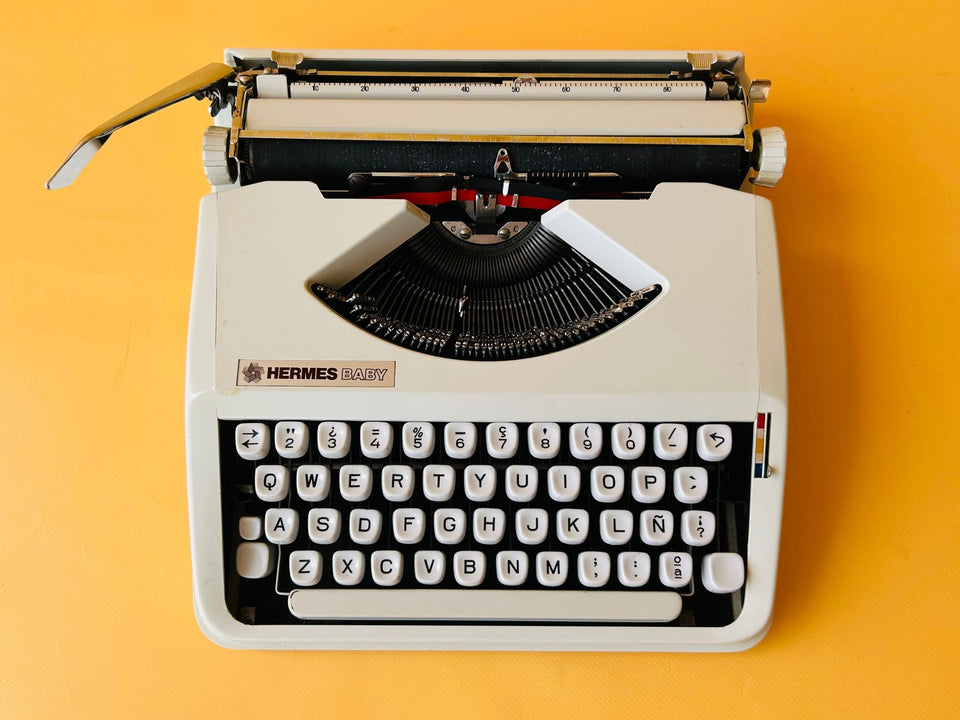 Detailed view of the white Spanish QWERTY keyboard on a Hermes Baby showing the Ñ key and crisp black lettering.