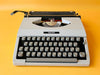 Detailed shot of the Spanish QWERTY keyboard on a gray Royal Safari, showing the pristine white keys, Ñ key, and the signature chrome ribbon selector accent
