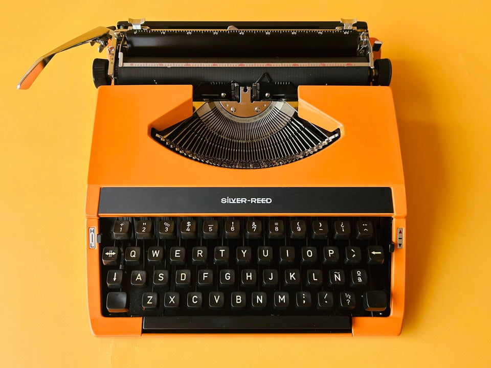 Detailed shot of the Spanish QWERTY keyboard on an orange Silver Reed featuring the Ñ key and crisp black keycaps