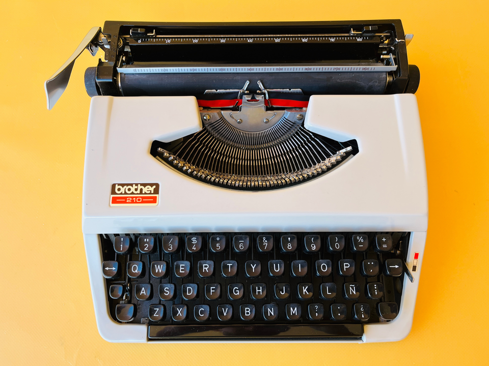 Detailed shot of the Spanish QWERTY keyboard on a Brother 210 showing the pristine black keycaps and the 'A' key mechanism.