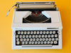 Detailed macro shot of the Spanish QWERTY keyboard on a Royal Contessa 2, showing the clean white block keys, the 'Ñ' key, and the distinct 'TA Royal' and 'Contessa 2 de luxe' branding badges.