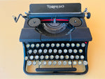 Close-up of a crisp red and black text type sample sheet inserted in the carriage roll