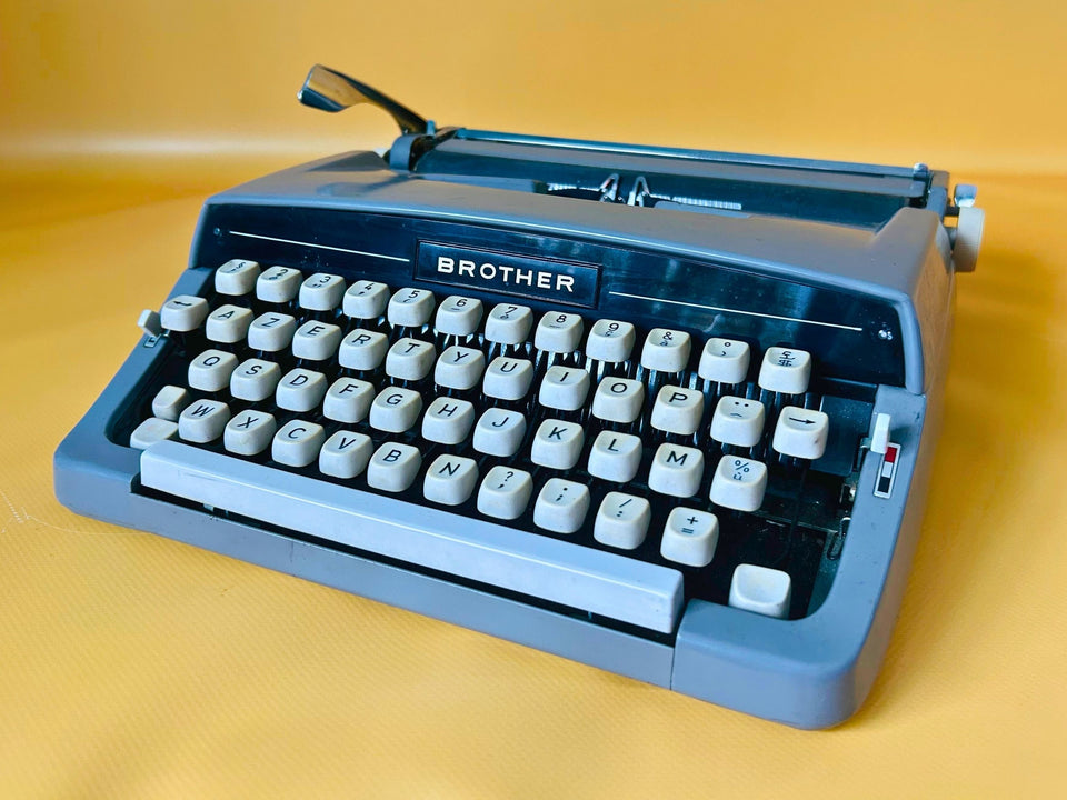 Blue Brother Deluxe portable typewriter with AZERTY keyboard displayed on yellow background