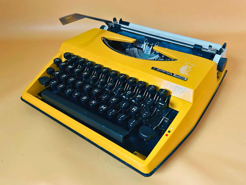 Adler Tippa S yellow portable typewriter with Spanish QWERTY keyboard and original case