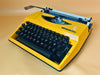 Adler Tippa S yellow portable typewriter with Spanish QWERTY keyboard and original case