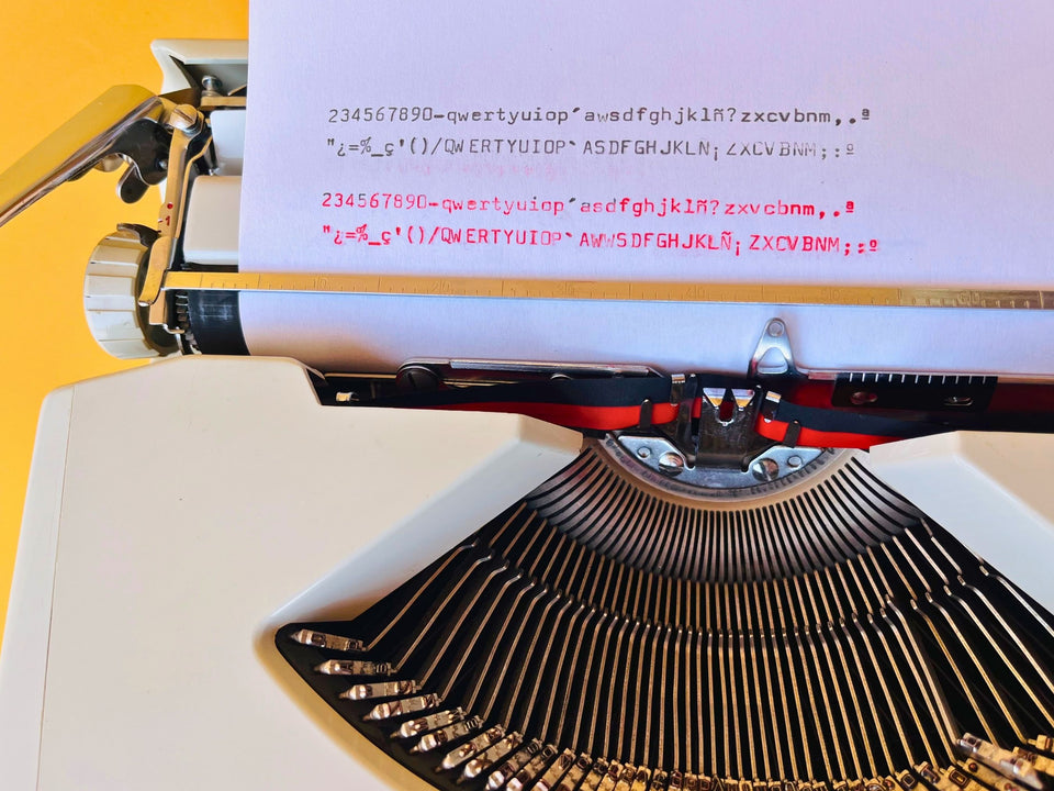 Hermes baby typewriter close typesample shot QWERTY on yello wbackground