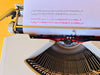 Hermes baby typewriter close typesample shot QWERTY on yello wbackground