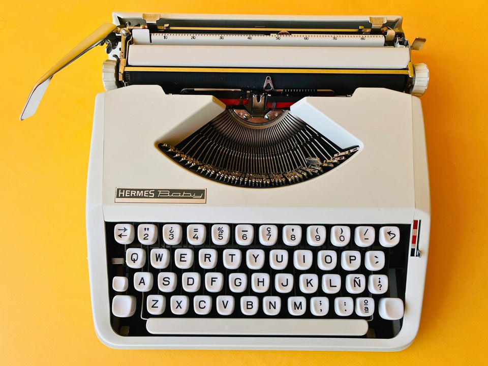 Hermes baby typewriter close keyboard shot QWERTY on yello wbackground