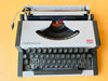 Working typewriter AEG Olympia Traveller de Luxe white top view showing type basket and ribbon