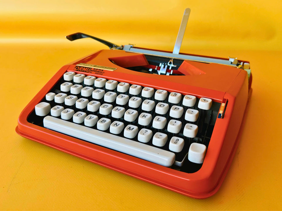 Working typewriter Hermes Baby orange QWERTY keyboard close-up