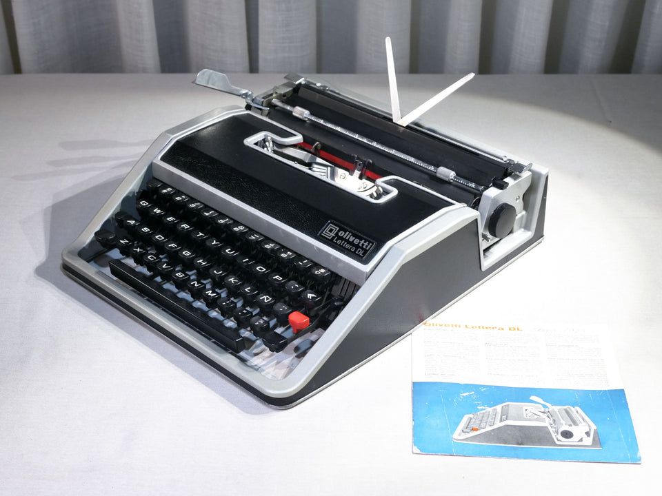 Front view of a mint condition black leather-clad Olivetti Lettera DL typewriter with silver aluminum trim.