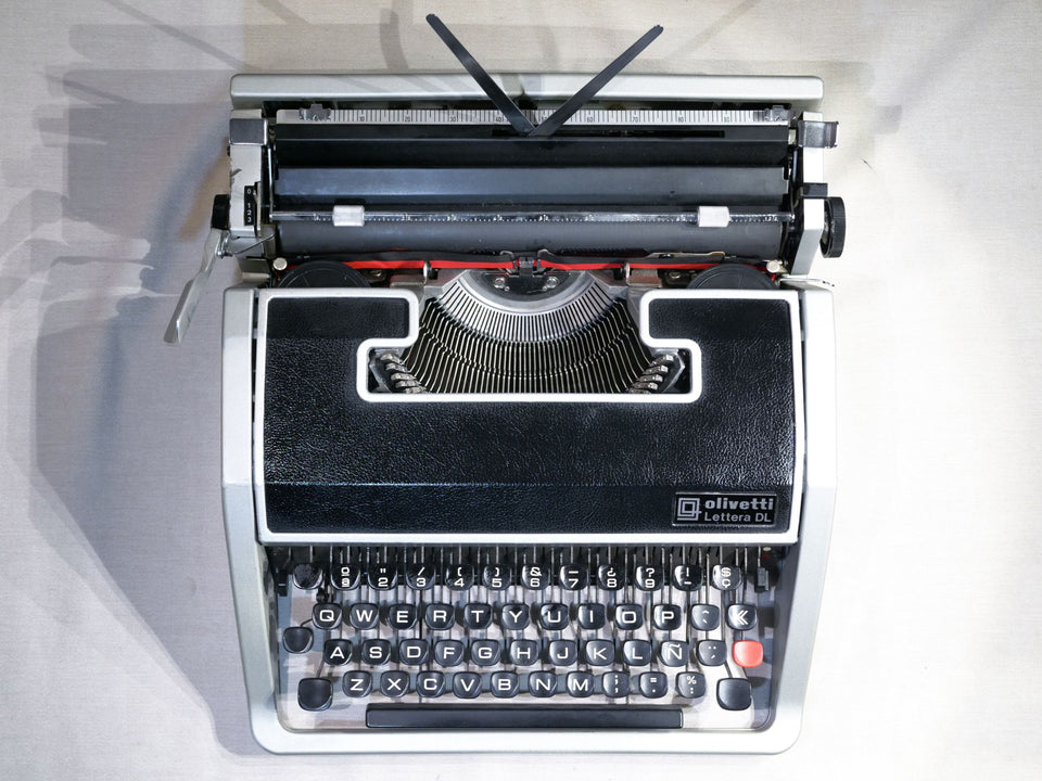 Close-up of the professional Spanish QWERTY keyboard on an Olivetti Lettera DL showing the Ñ key and sleek round keys.