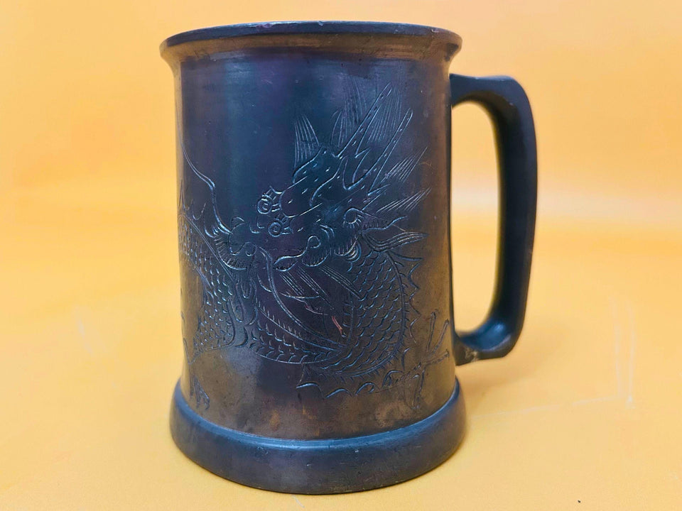 Pewter beer mugs detail engraved dragon design close-up